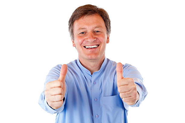 Older, attractive, happy smiling senior man shows both thumbs up stock photo