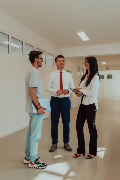 istock The director conducts a conversation with the secretary and a young programmer in a modern and spacious corridor of a large company, discussing various business topics and projects. 1531652027