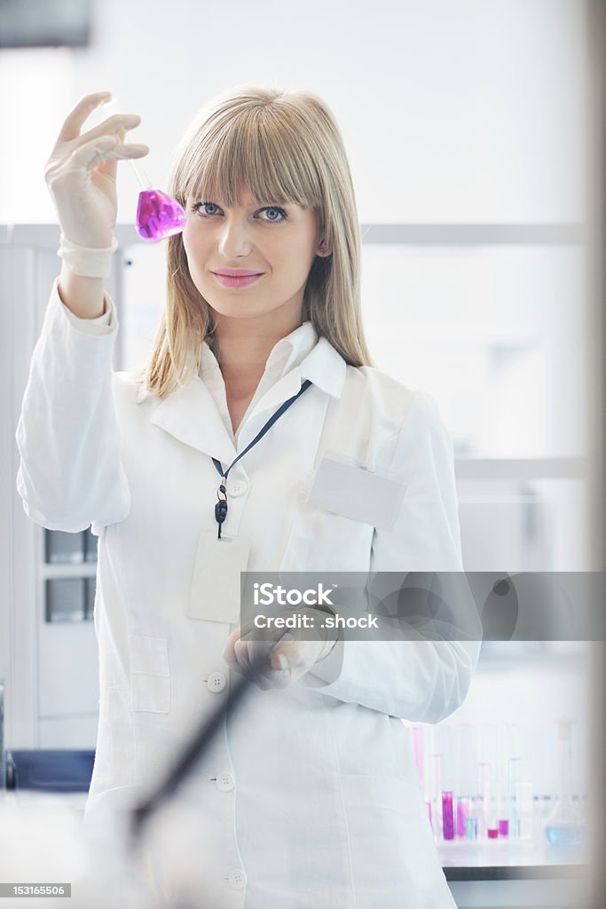 Investigador femenino con capacidad de un tubo de ensayo en laboratorio - Foto de stock de Adulto libre de derechos