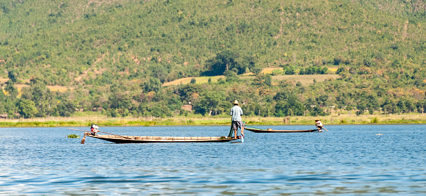 Nyaung  Shwe, Inle Lake, Myanmar - nov 10,2012 : a fisherman fishing from his slender canoe carved from a single tree trunk on Lake Inle