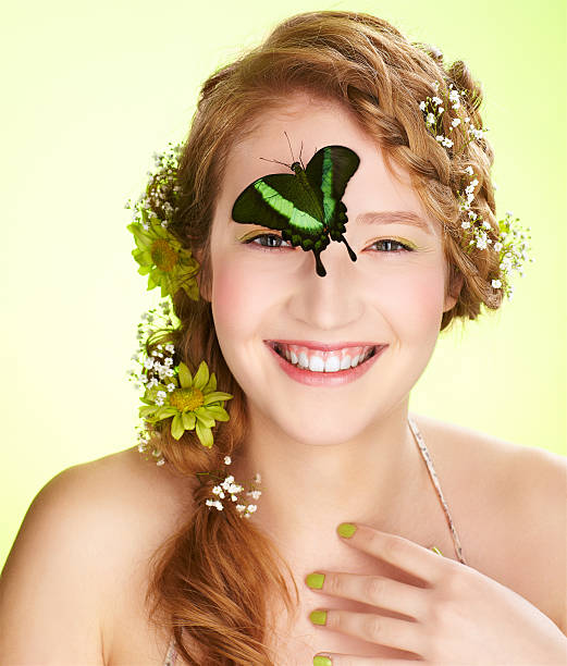 beautiful girl and butterfly expression portrait of beautiful healthy smiling redhead teen girl with flowers in her hair holding butterfly on her face papilio palinurus stock pictures, royalty-free photos & images