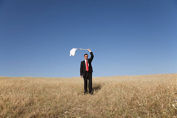 Defeated businessman businessman asking for surrendering with a white flag business person one man only blue standing stock pictures, royalty-free photos & images