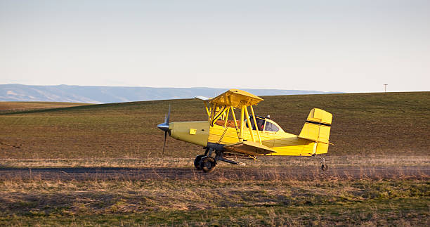 istock Crop duster taking off rough strip with spring field 153168643
