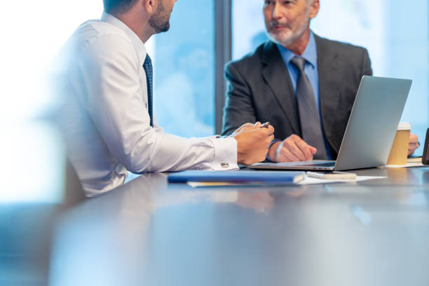 istock Two business men talking and working on a laptop computer 1531696458
