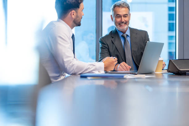 istock Two business men talking and working on a laptop computer 1531697214
