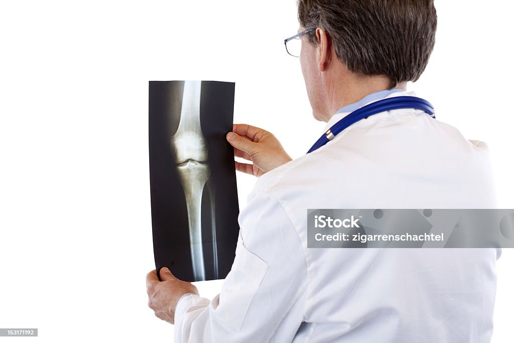 Используя Старший мужской доктор глядя на рентгеновских изображений, сделанных - Стоковые фото Рентгеновский снимок роялти-фри