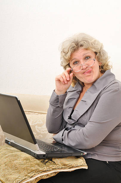 istock teasing middle-aged woman showing her tongue 153173613