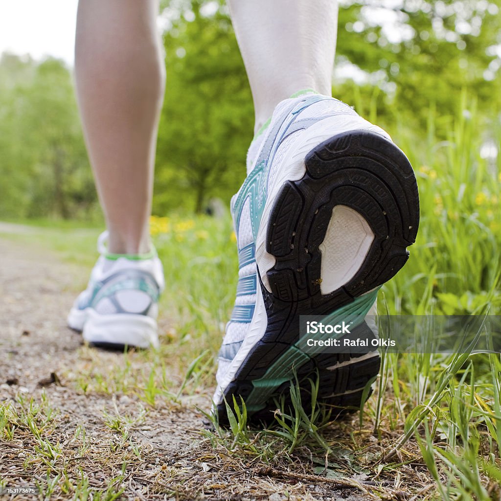Woman walking cross country and trail in spring forest Human Foot Stock Photo