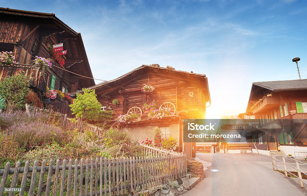 Maisons de campagne suisse traditionnelle avec des décorations dans les Alpes au coucher du soleil. - Photo de Suisse libre de droits