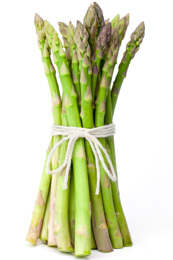 A bundle of asparagus tied together with twine isolated on a white background