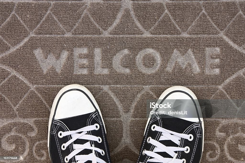 Alfombrilla de bienvenida con blanco y negro Zapatillas - Foto de stock de Cartel de bienvenida libre de derechos