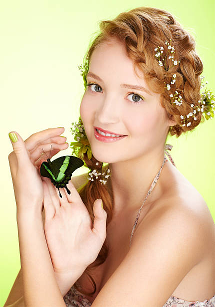 beautiful girl and butterfly portrait of beautiful healthy redhead teen girl with flowers in her hair holding butterfly on hand papilio palinurus stock pictures, royalty-free photos & images