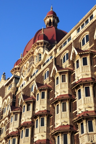 The famous Taj Mahal Hotel seen from the seaside promenade below.  The most iconic and imposing structures in the trendy Colaba district of Mumbai.  Once the playground of rich and well to do English colonials, remains as an elegant landmark.