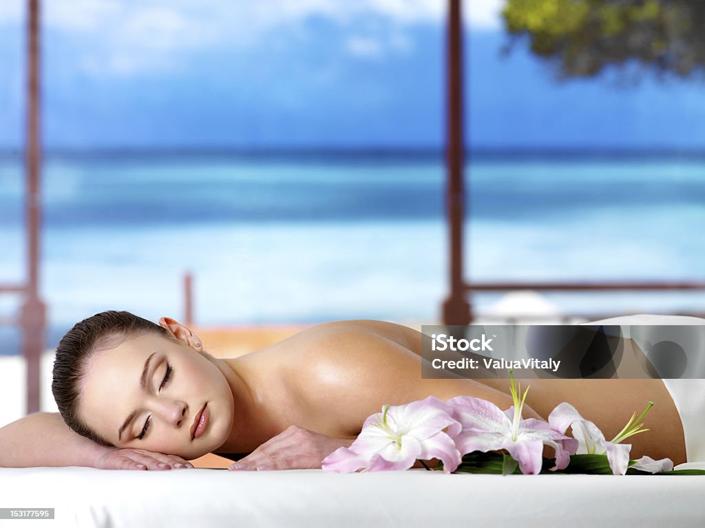 Woman relaxing in spa salon Beautiful young woman relaxing in the spa  salon in a resort - nature background Adult Stock Photo