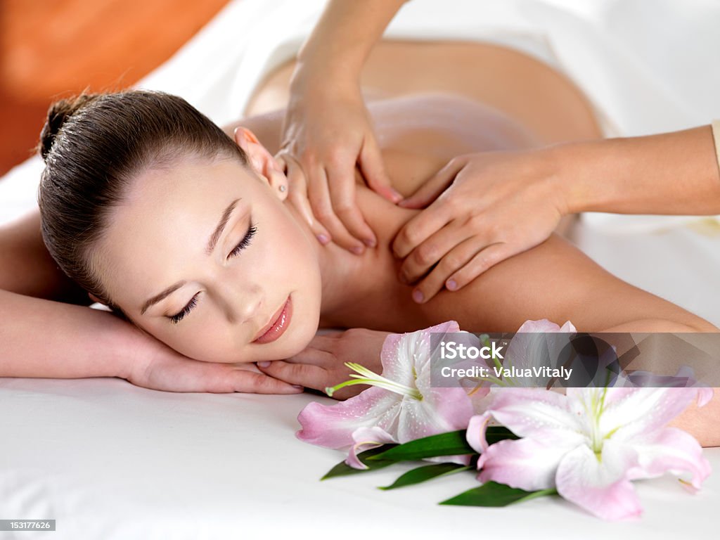 Uśmiechnięta kobieta coraz masażu w spa - Zbiór zdjęć royalty-free (Ciało ludzkie)