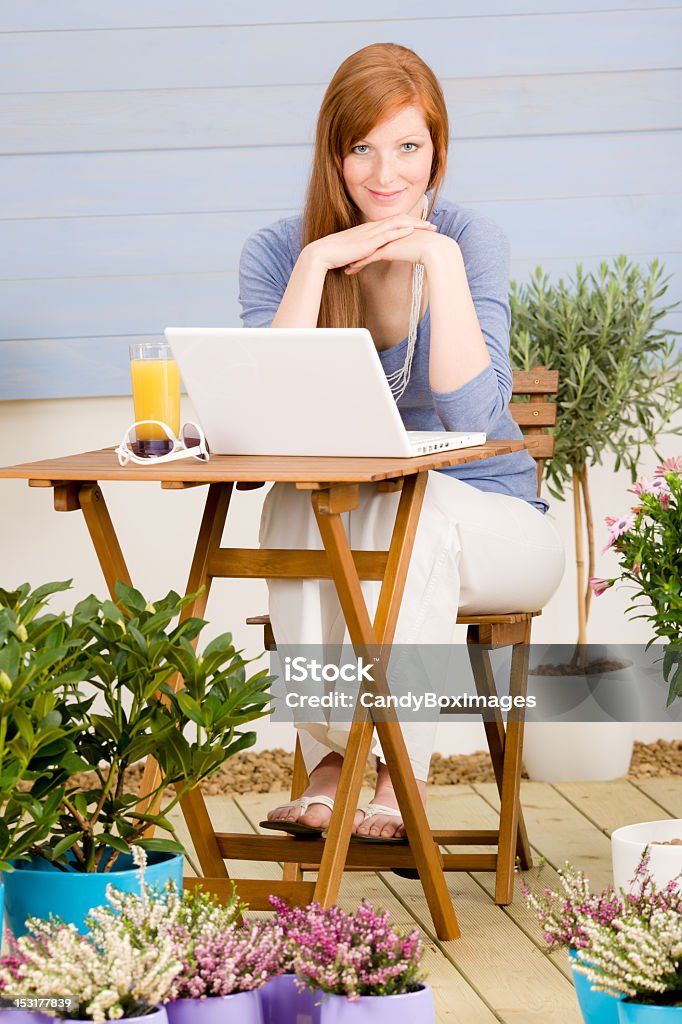 Summer terrace Rude włosy kobieta z laptopa - Zbiór zdjęć royalty-free (Dorosły)
