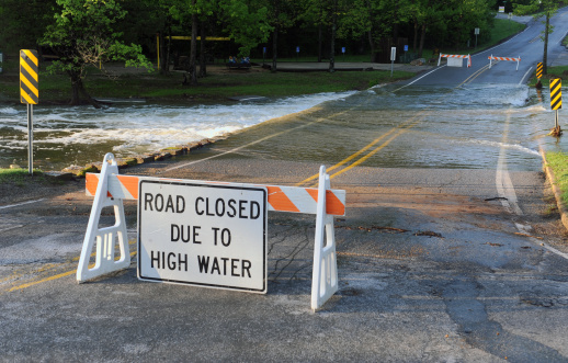 Road Closed sign due to high water in front of water crossing over the road