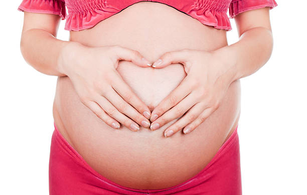 istock pregnant woman making heart shape 153178695
