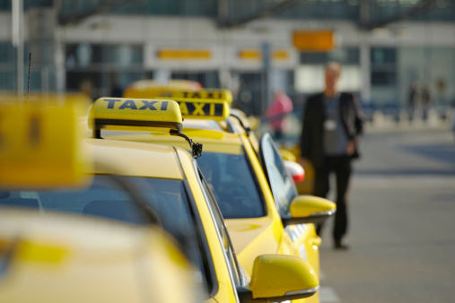 Taxi car are waiting in row in front of the terminal Prague Airport.