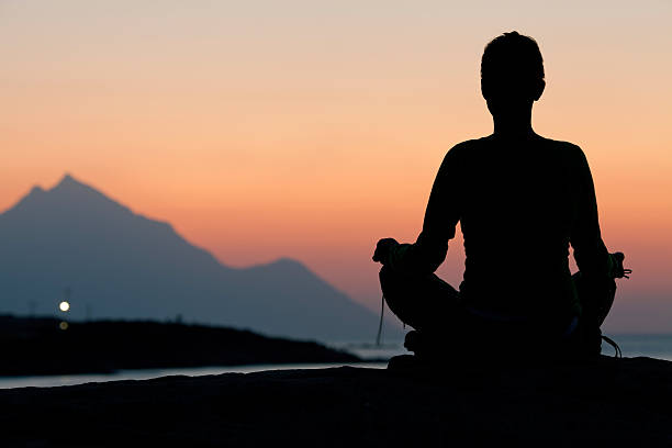 istock Woman meditating on sunrise 153179967