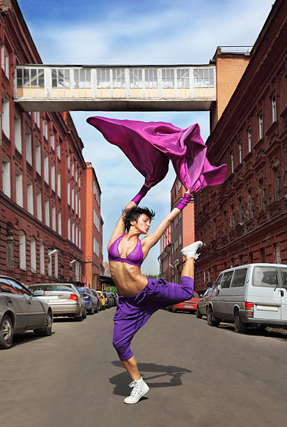 istock Slim girl dancing with raised leg between buildings 153181265