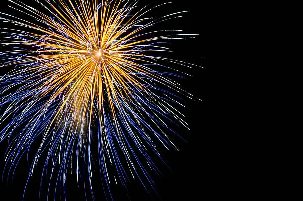 A firework Shimmering with a blue and orange spark.