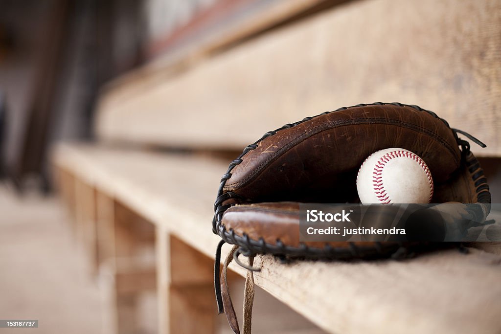 Catcher's Mitt in Dugout Catcher's mitt lays in an empty dugout with a baseball inside. Sports Dugout Stock Photo