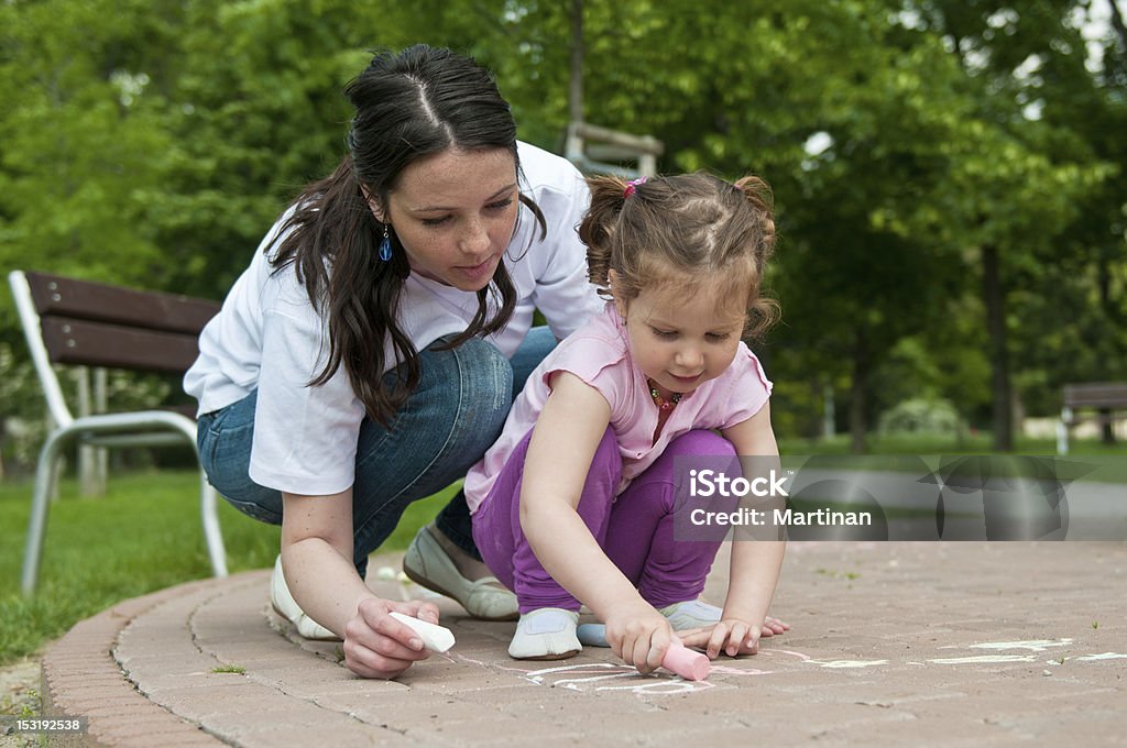 Mãe ensina a sua criança desenho na calçada - Foto de stock de Calçada royalty-free