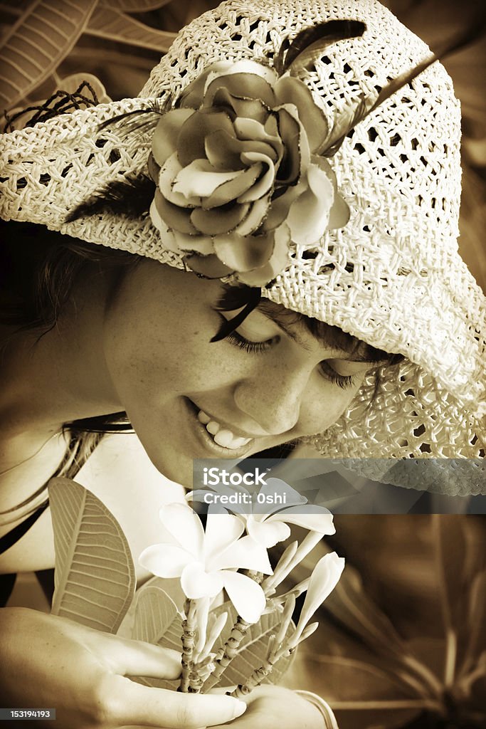 Young woman smelling tropical flowers MORE IMAGES OF THE SAME MODEL: 20-29 Years Stock Photo