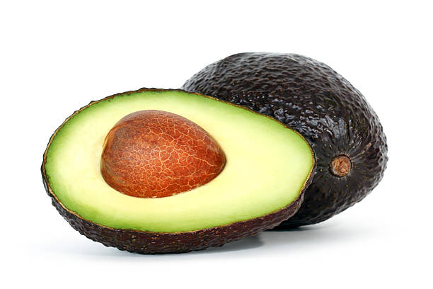istock An avocado half with a brown seed and a whole avocado 153194196