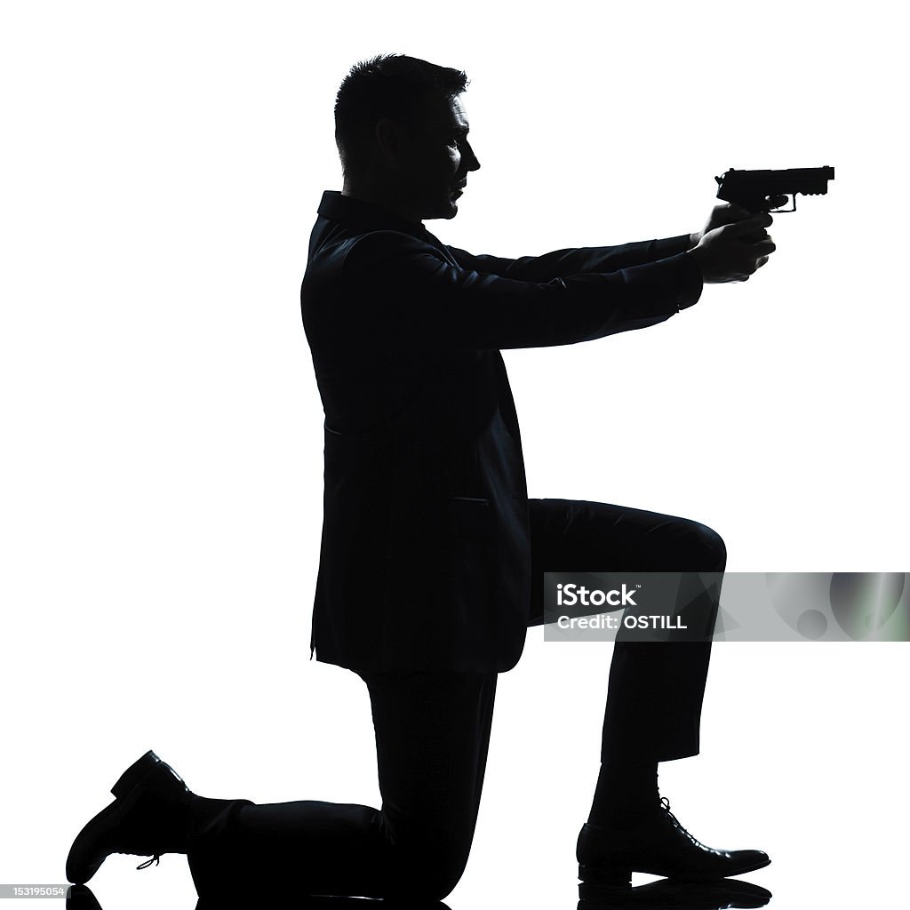 silhouette uomo in ginocchio Pistola puntamento - Foto stock royalty-free di Adulto