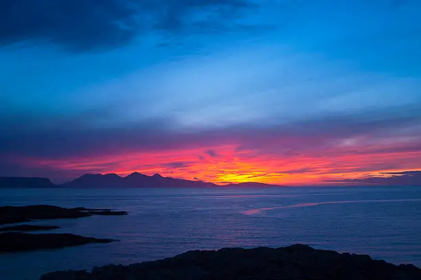 Sunset over the Inner Hebridean Islands of Eigg and Rum from Portnaluchaig. Photographed from 56° 56' 25.55" N, 5° 51' 43.64" W    B8008, Arisaig, Highland PH39, UK