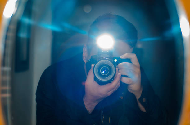 istock Man taking selfie with professional camera in a mirror and copy space 1531957269