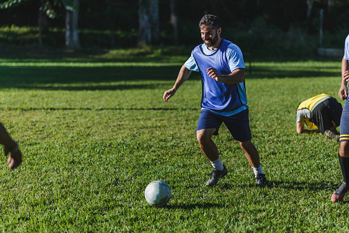 Man preparing to kick the ball on the soccer field.