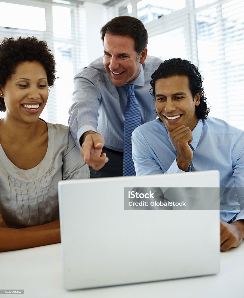 Ludzie biznesu Patrząc na laptopa i uśmiechając się w biurze. - Zbiór zdjęć royalty-free (20-24 lata)
