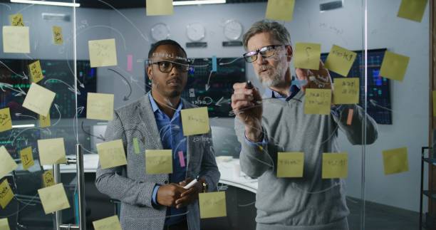 istock Financial analysts draw on glass wall, develop business strategy 1532019602