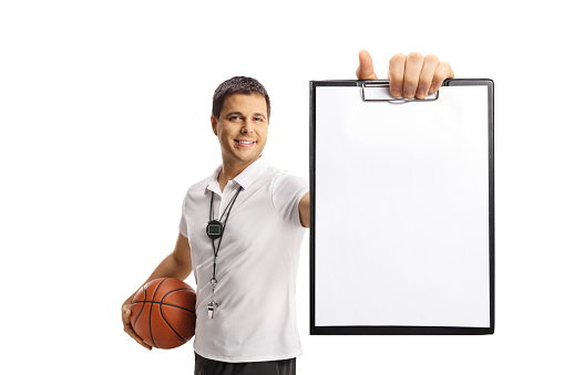 Basketball coach holding a ball and showing a paper document isolated on white background