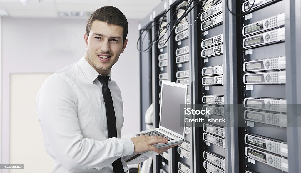 businessman with laptop in network server room young engeneer business man with thin modern aluminium laptop in network server room Server Room Stock Photo