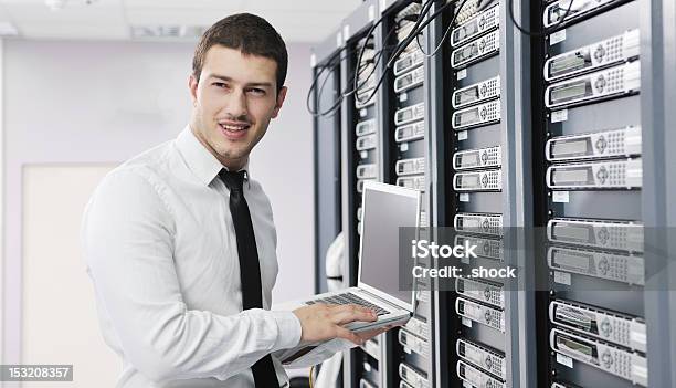 Businessman With Laptop In Network Server Room Stock Photo - Download Image Now - Server Room, Adult, Backup