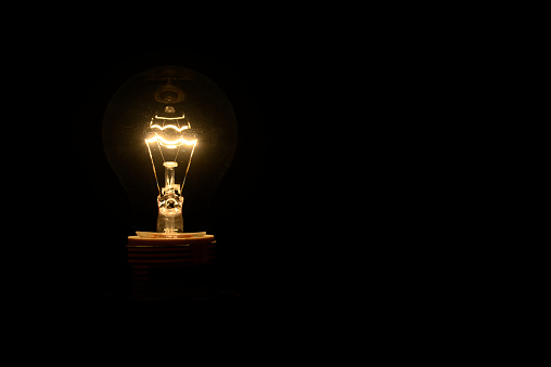 Vintage incandescent bulb emits warm, nostalgic glow with timeless charm.