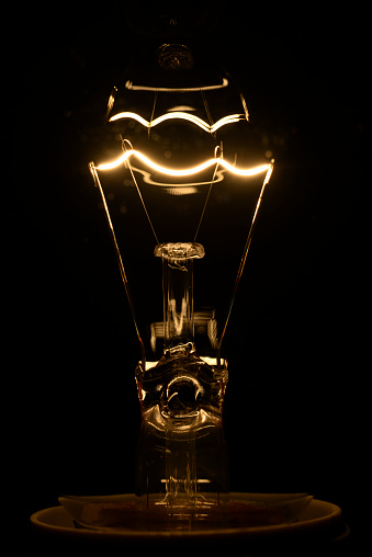 Vintage incandescent bulb emits warm, nostalgic glow with timeless charm.