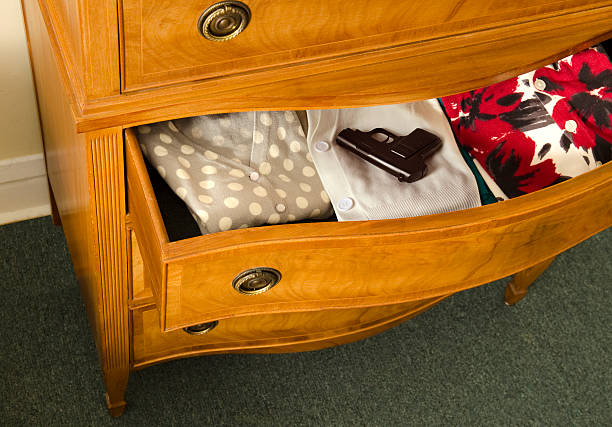 open dresser drawer with gun stock photo