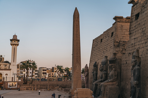 07/03/2023,Luxor,Egypt: Tourists from different backgrounds walking  in front of an obelisk and the entrance of Luxor Temple.Four statues of Ramses can be seen. Luxor Temple is one of the most important tourist attractions in Egypt.
