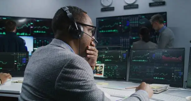 Photo of African American investor with pen in hand works