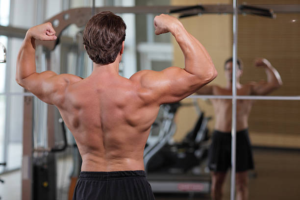 bodybuilder flexionando na academia de ginástica - human muscle flash - fotografias e filmes do acervo