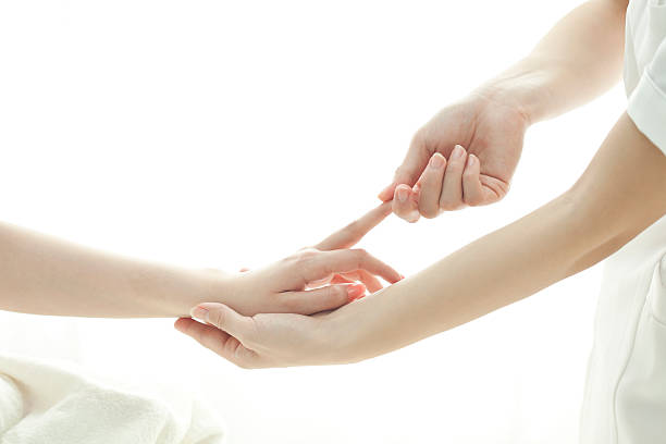 la mano de un esteticista que masajes - massaging human arm obscured face only women fotografías e imágenes de stock
