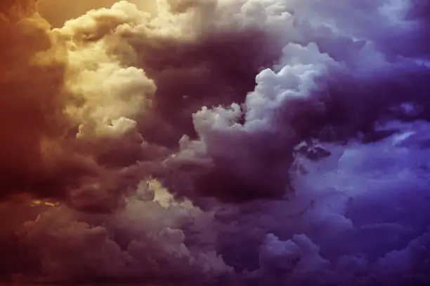 Photo of Yellow orange red purple violet blue clouds. Storm rain wind. Dark dramatic sky. Flash glow light lightning. Background.