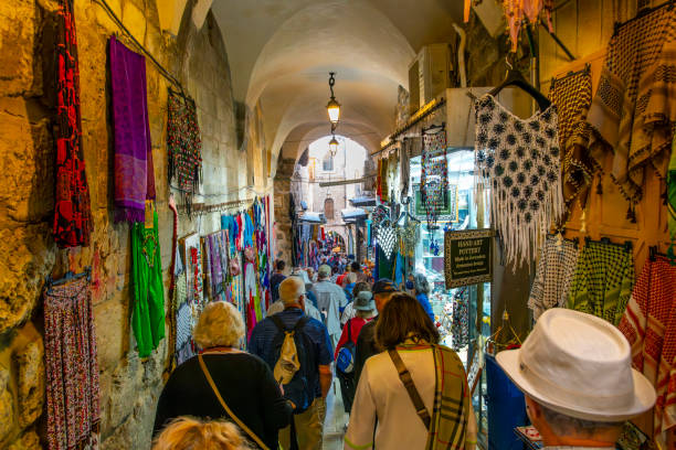 un estrecho pasadizo de túnel lleno de gente a través del histórico mercado y bazar en la ciudad vieja de jerusalén, israel. - jerusalem middle east architecture jerusalem old city fotografías e imágenes de stock