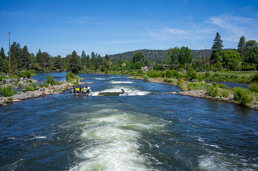 Bend OR, USA - June 16th, 2023: People surfing the Deschutes River Whitewater park on a sunny summer day in Bend Oregon