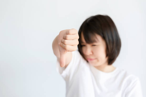 istock Asian woman holding up disliked finger on white background. 1532201963